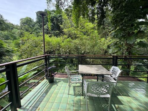 a patio with a table and chairs on a deck at Top River Nest- Upper Floor 