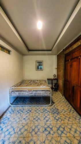 a bedroom with a bed and a tile floor at Rumah Gaharu - Wetan 