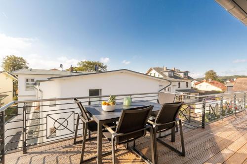 Un patio con una mesa y sillas en un balcón. en Quartier 7 App 13, en Ahlbeck