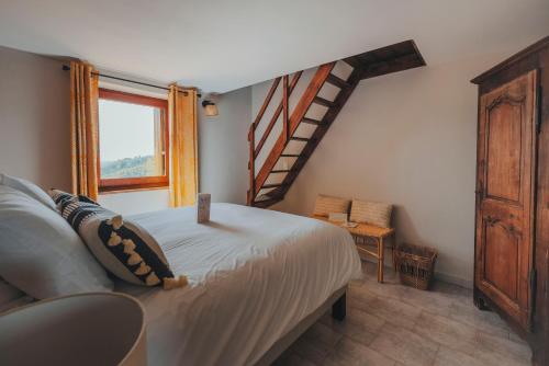 a bedroom with a bed and a stair case at Les Terrasses de la Borie in Mandagout