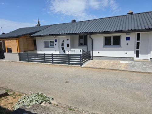 a white house with a black roof at Tiny House Ciciban - self check in and check out in Otočac