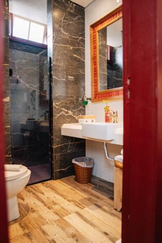 a bathroom with a sink and a shower and a toilet at Pousada Do Largo in Tiradentes