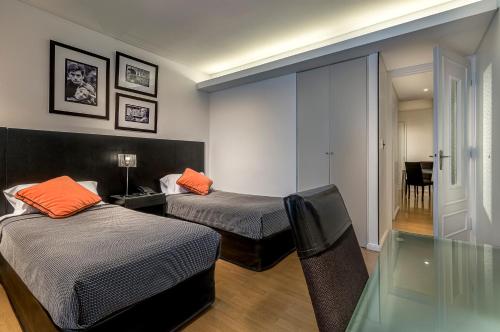 a room with two beds and a glass table at Apart by Broadway in Buenos Aires