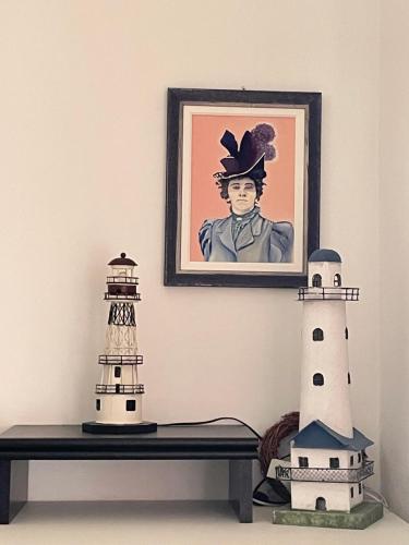 a table with two lighthouses and a picture of a man at Ars in Villa in Livorno