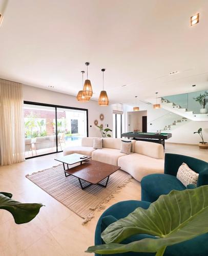 a living room with a couch and a pool table at Villa Ubud Hammamet in Hammamet Sud