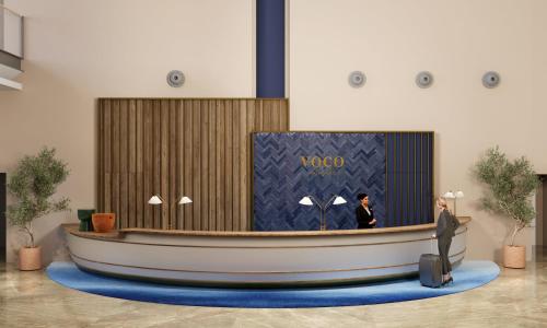 a man in a suit standing in front of a lobby at Holiday Inn Nola - Naples Vulcano Buono by IHG in Nola