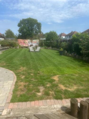 a lawn with two white chairs in a yard at The Hideaway in Derby