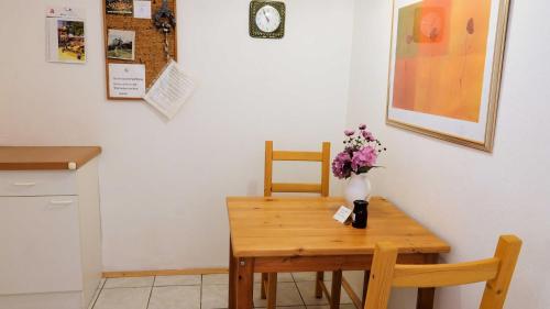 a table with two chairs and a vase of flowers on it at Ferienwohnung Armitter in Neckargemünd
