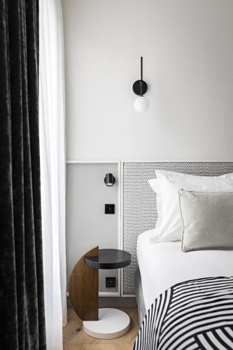 a bedroom with a bed and a table next to a bed at Best Western Premier The Blake Paris Gare Saint Lazare in Paris