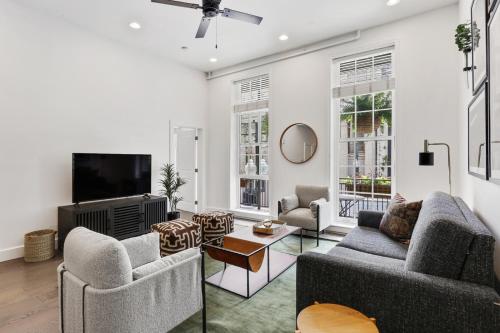 a living room with two couches and a tv at Roami at Bourbon Place in New Orleans
