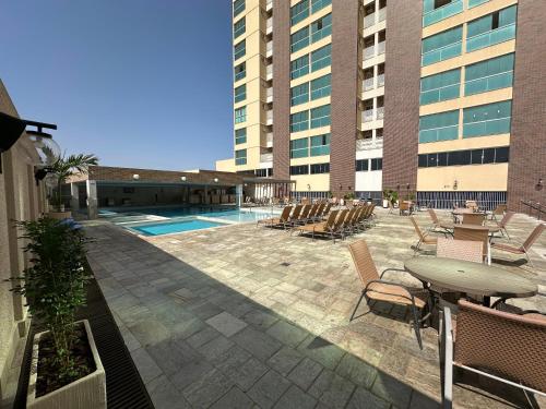 a patio with a table and chairs and a pool at Piazza diRoma com acesso ao Acqua Park e Splash - Gabriel in Caldas Novas