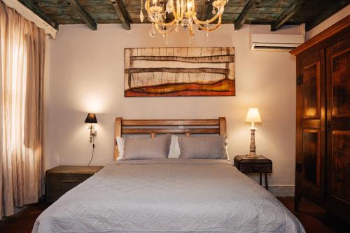 a bedroom with a bed and a chandelier at Pousada Do Largo in Tiradentes