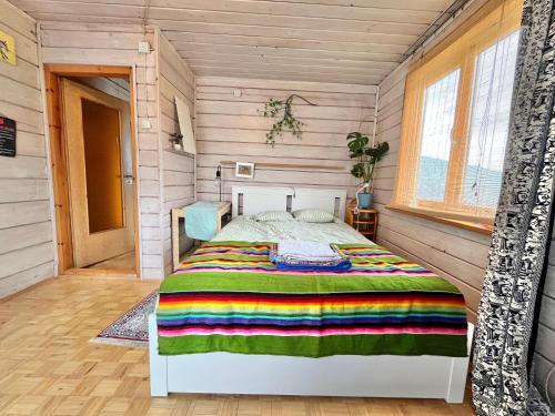 a bedroom with a bed in a room with wooden walls at Dom Ponad Wsią in Zawoja