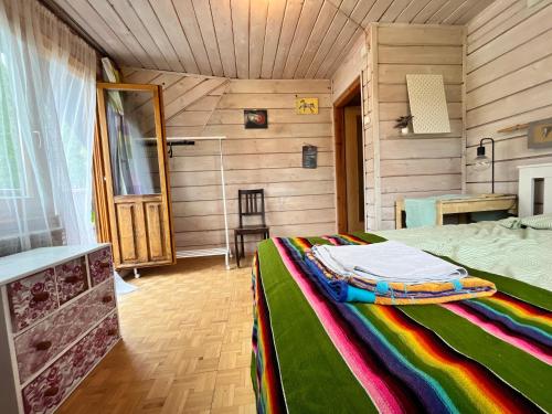 a bedroom with a bed with a colorful blanket at Dom Ponad Wsią in Zawoja