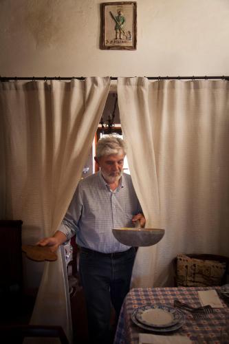 a man holding a plate in front of a table at Agriturismo Santa Maria in Torrita di Siena