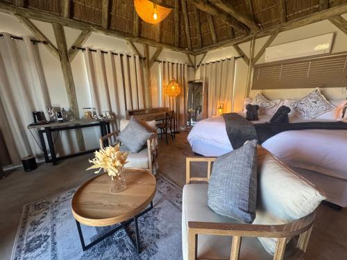 a bedroom with two beds and a table and chairs at Tsauchab River Camp in Sesriem