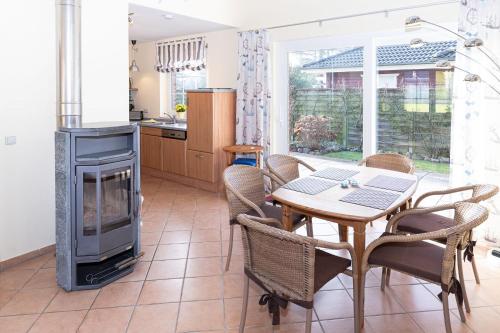 a living room with a table and a fireplace at Ferienhaus Satelsrönne 23 - Wattlaeufer in Duhnen