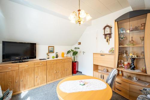 ein Esszimmer mit Tisch und Fernseher in der Unterkunft Ferienwohnung Sellin 35 in Sellin