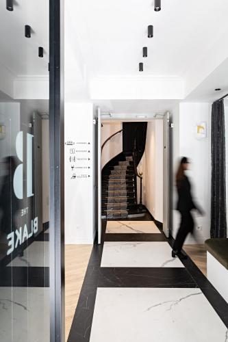 a person walking down a hallway with a staircase at Best Western Premier The Blake Paris Gare Saint Lazare in Paris