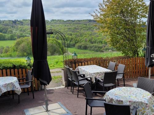 a patio with tables and chairs and an umbrella at Ferienwohnung Landidylle in Birx