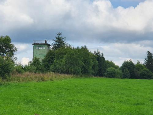 a green field with a tower in the distance at Ferienwohnung Landidylle in Birx