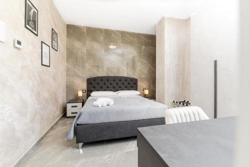 a bedroom with a large bed and a table at Nova Suite in Catania