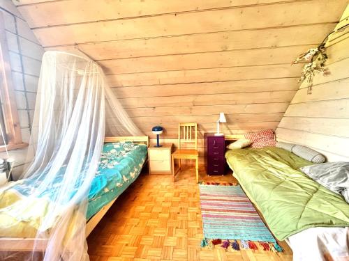 a bedroom with two beds in a room with wooden walls at Dom Ponad Wsią in Zawoja