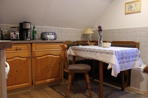 a kitchen with a table and a chair with a table at Ferienwohnung Landidylle in Birx