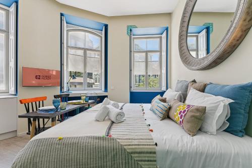 a living room with a couch and a mirror at GuestReady - AMMA Braga Apartments in Braga
