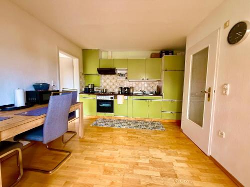 une cuisine avec des placards verts et une table en bois dans l'établissement Family Apartment Bayreuth Festspielhaus, à Bayreuth