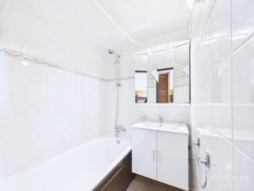 une salle de bain blanche avec une baignoire et un lavabo dans l'établissement Studio Mezzanine avec Balcon Exposé Sud, Pieds des Pistes, Proche Commerces et Garderie - FR-1-398-563, à La Rosière