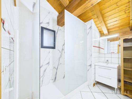 une salle de bain blanche avec une douche et un lavabo dans l'établissement Duplex 5 pièces, 100m des pistes, Parking et WIFI - FR-1-398-644, à Montvalezan