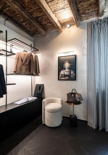 a room with a chair and a table with a coat at Dimora San Nicola Charming Suite in Conversano
