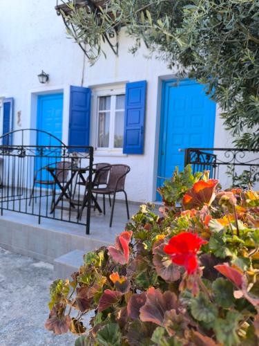 a house with blue doors and flowers in front of it at Villa Orizontes in Spetses