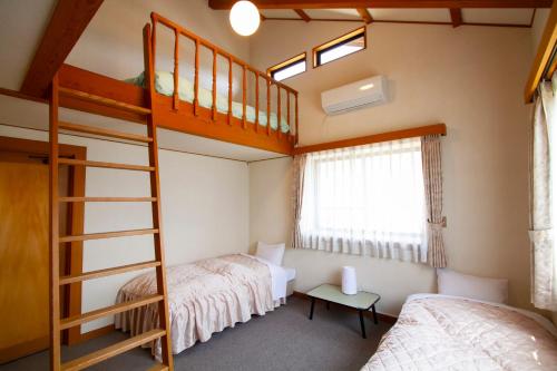 a bedroom with two bunk beds and a ladder at 里山でのんびり遊べる宿-風音翆舎 Kanon suisha in Kawaba