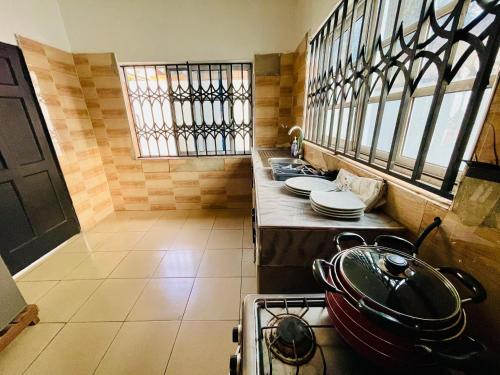 una cucina con piano cottura e fornelli forno superiore di Privacy & Comfort Your Home Away From Home- 2 Bedroom House Free WiFi close to Santasi-Kumasi a Kumasi