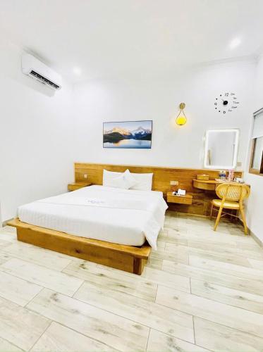 a bedroom with a large bed and a desk at HOLIDAY HOTEL PHAN THiẾT in Ấp Bình Hưng