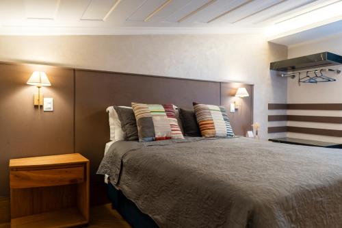 a bedroom with a large bed with two pillows at Pousada Do Largo in Tiradentes
