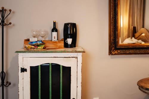 a small table with wine glasses and a mirror at Pousada Do Largo in Tiradentes