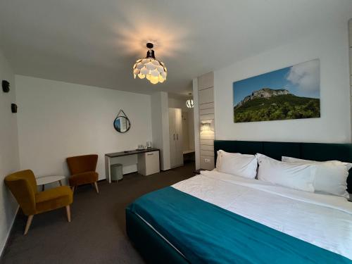 a hotel room with a bed and a chandelier at Pensiunea Georgiana in Durau