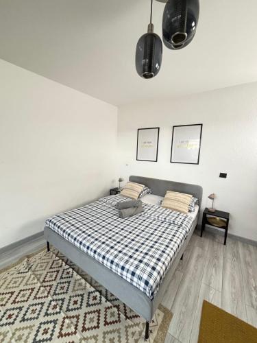 a bedroom with a bed with a checkered blanket at Soh Rent Strasbourg Wifi Terrasse St Aloise in Strasbourg