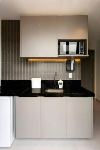 a kitchen with a sink and a microwave at Simple Smart By Xtay - Novo, aconchegante e a 7min do Manaíra Shopping in João Pessoa