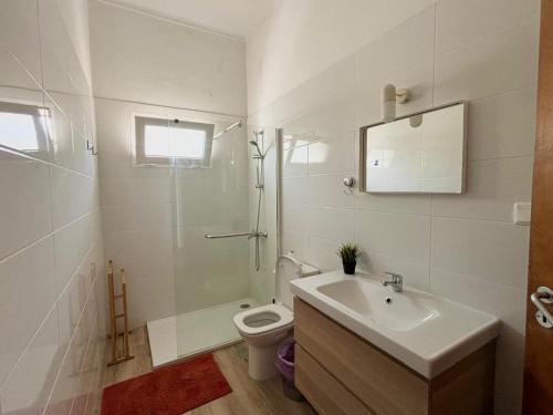 a white bathroom with a sink and a toilet at Anchor House in Albufeira