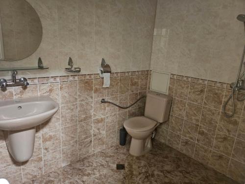 a bathroom with a toilet and a sink at Стая за двама в град Бургас in Burgas City