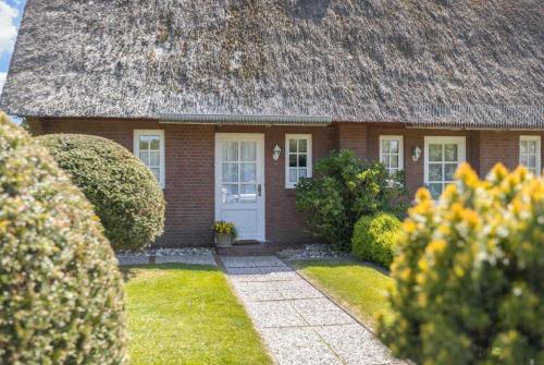 a small brick house with a grass roof at Haushaelfte 16a Lille Hus ID 450 in Tating