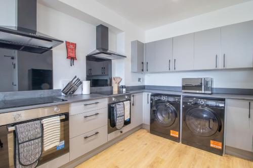 a kitchen with two washers and two washers at Alexandra Apartment in Falkirk