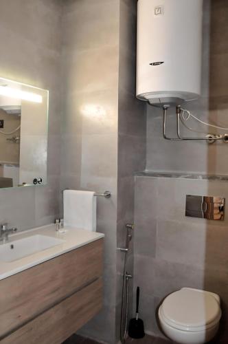 a bathroom with a sink and a toilet and a mirror at Dominium Residence in Agadir