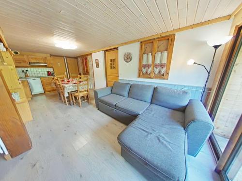 un salon avec un canapé bleu et une table dans l'établissement Appartement cosy 6 personnes avec grande terrasse et parking, près des activités - FR-1-241-181, au Grand-Bornand