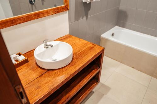 a bathroom with a sink and a bath tub at Tropical Space in Ubud