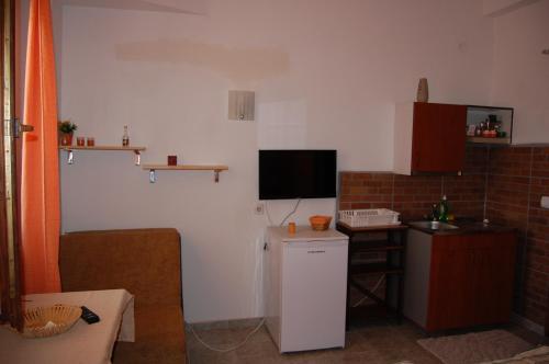 a small kitchen with a small refrigerator and a television at Apartments Sonja in Ohrid